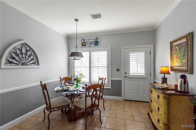 dining room with ornamental molding and light tile patterned floors