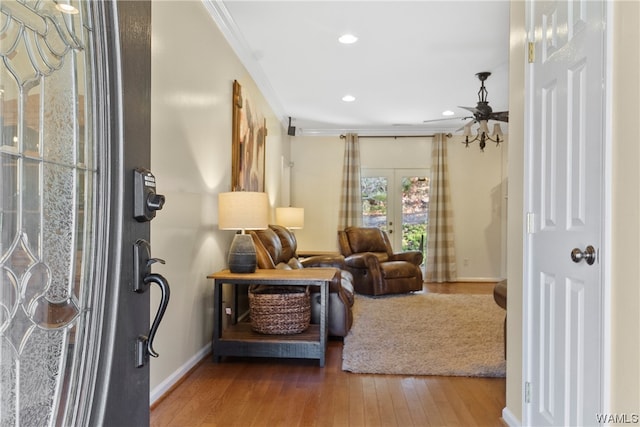 sitting room featuring hardwood / wood-style floors, ceiling fan, crown molding, and french doors