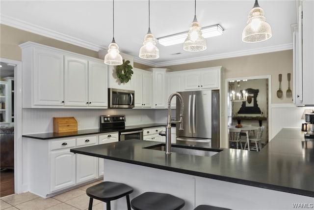 kitchen with white cabinets, stainless steel appliances, decorative light fixtures, and ornamental molding