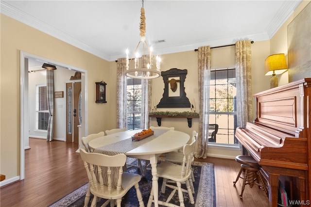 dining space featuring dark hardwood / wood-style flooring, crown molding, and an inviting chandelier