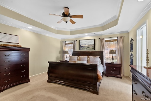 carpeted bedroom with a tray ceiling, ceiling fan, and crown molding