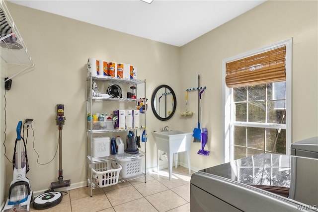 bathroom featuring tile patterned floors, washer / dryer, and sink