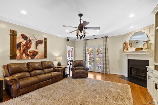 living room with hardwood / wood-style flooring, ceiling fan, ornamental molding, and french doors