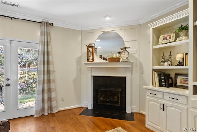 interior space featuring a fireplace, light hardwood / wood-style floors, and ornamental molding