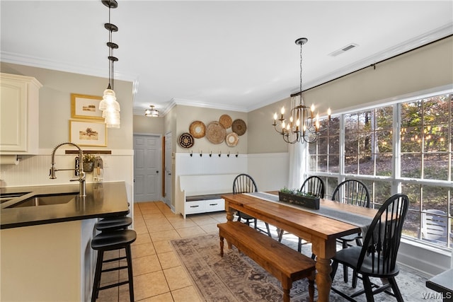 dining space featuring light tile patterned flooring, sink, crown molding, and an inviting chandelier