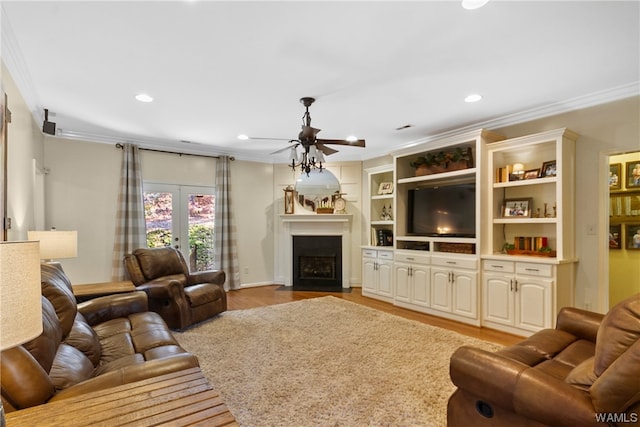 living room with french doors, light hardwood / wood-style floors, ceiling fan, and crown molding