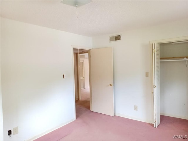 unfurnished bedroom featuring carpet, a closet, and a textured ceiling