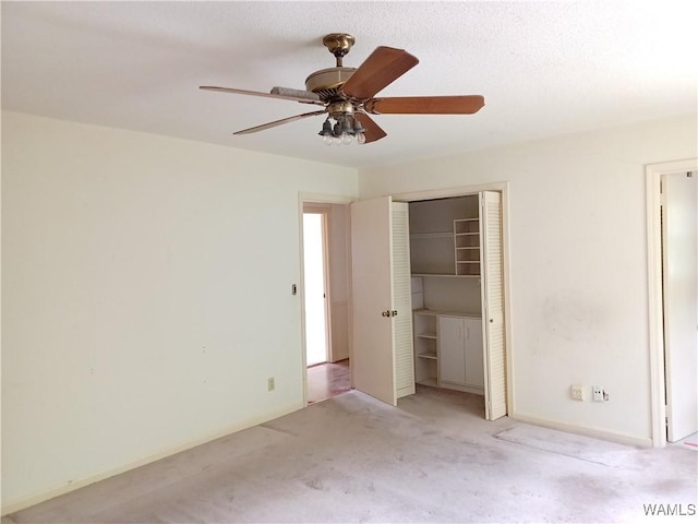 unfurnished bedroom featuring carpet floors, a closet, a ceiling fan, and baseboards