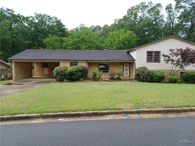 view of front facade with brick siding, asphalt driveway, a front lawn, and an attached carport