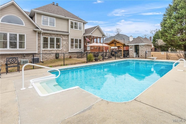 view of swimming pool featuring fence, a diving board, a fenced in pool, and a patio