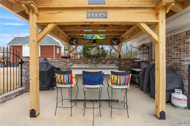 view of patio with outdoor dry bar and area for grilling