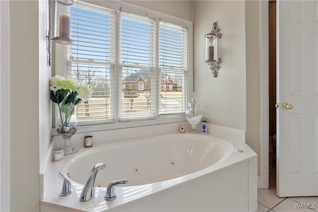 bathroom with tile patterned flooring and a bath