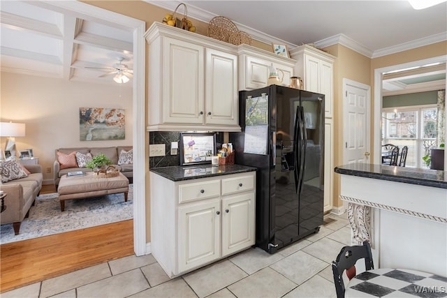 kitchen featuring crown molding, light tile patterned floors, black refrigerator with ice dispenser, open floor plan, and coffered ceiling