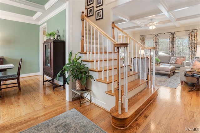 stairway featuring coffered ceiling, beamed ceiling, baseboards, and wood finished floors