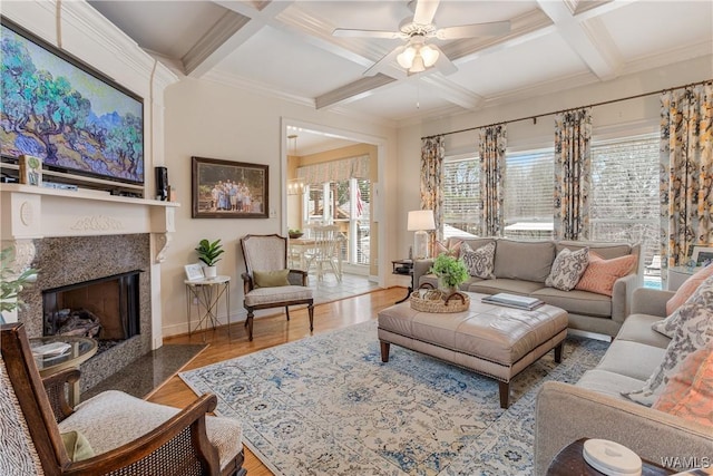 living room with beamed ceiling, coffered ceiling, wood finished floors, and a high end fireplace