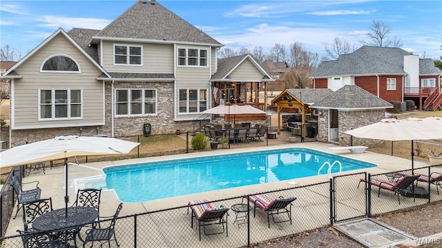 view of swimming pool featuring a patio area, fence, and a fenced in pool