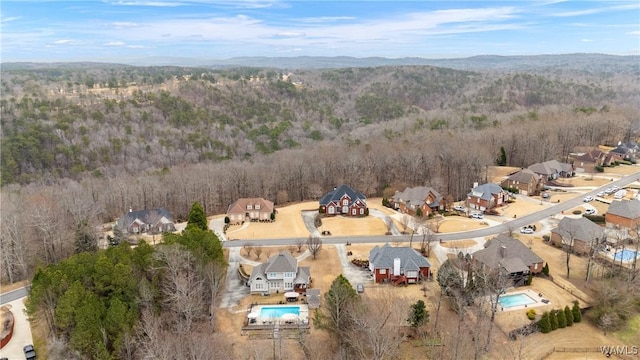 drone / aerial view featuring a wooded view and a residential view