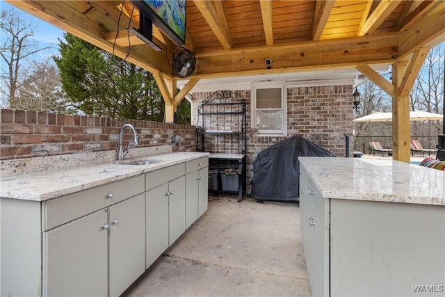 view of patio / terrace featuring outdoor wet bar, area for grilling, a grill, and a sink