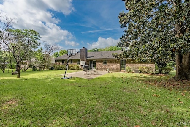 3709 Diamond Ln, Northport, AL 35473 - rear view of property with a patio area, a lawn, brick siding, and a chimney