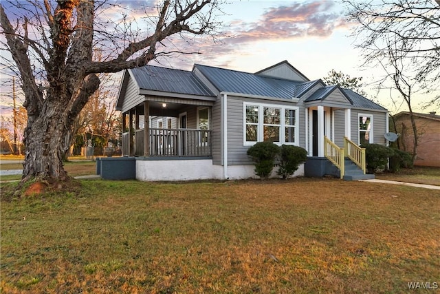 view of front of property with metal roof and a front yard