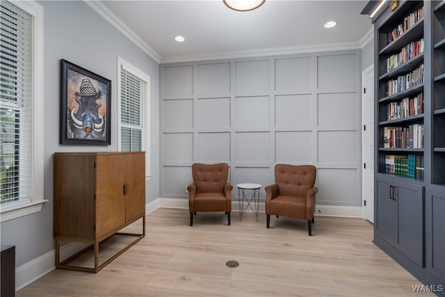 living area with ornamental molding and light wood-type flooring