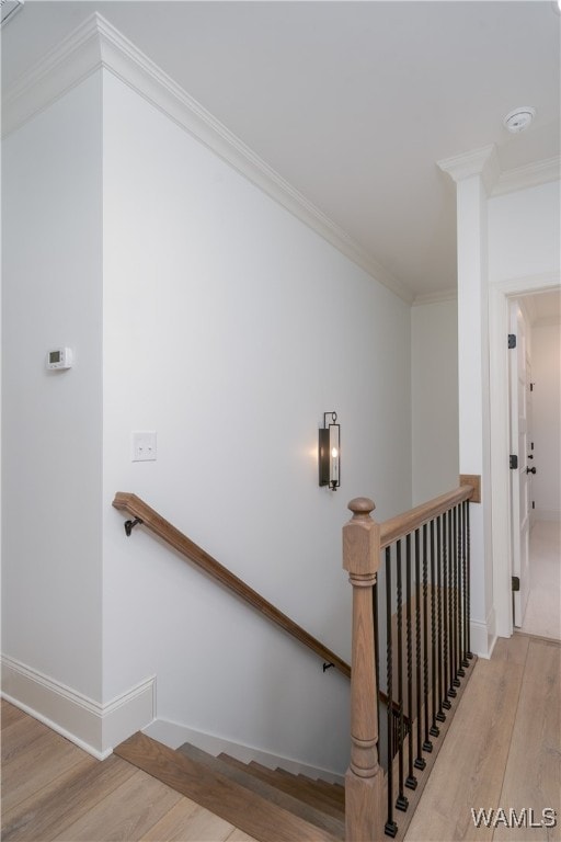 stairway featuring hardwood / wood-style floors and ornamental molding