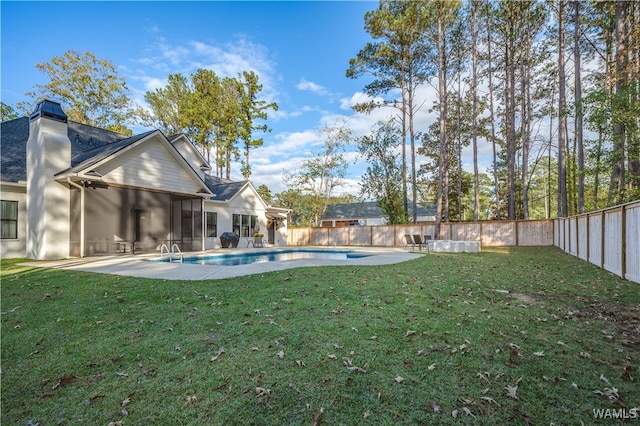 view of yard with a fenced in pool, a patio area, and a sunroom