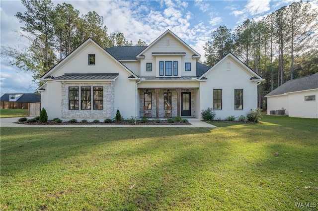 view of front of property with covered porch, central air condition unit, and a front yard