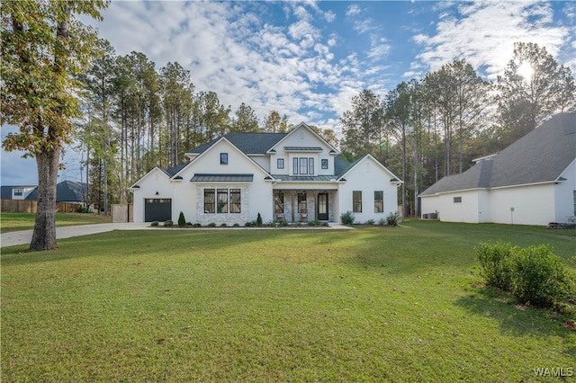 view of front of house with covered porch, a garage, and a front lawn