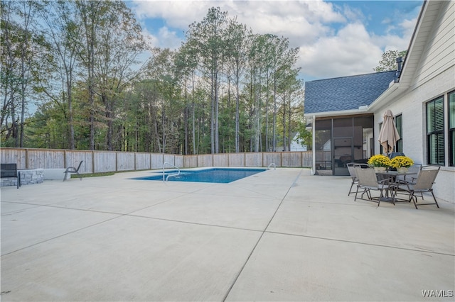 view of swimming pool with a sunroom and a patio