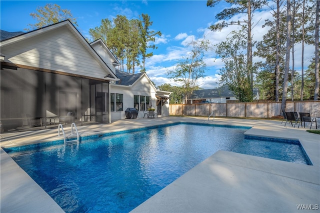 view of swimming pool featuring a patio area and a sunroom