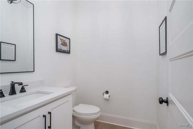 bathroom featuring hardwood / wood-style floors, vanity, and toilet