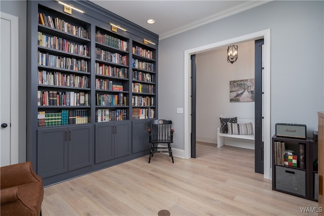 living area featuring light wood-type flooring and ornamental molding