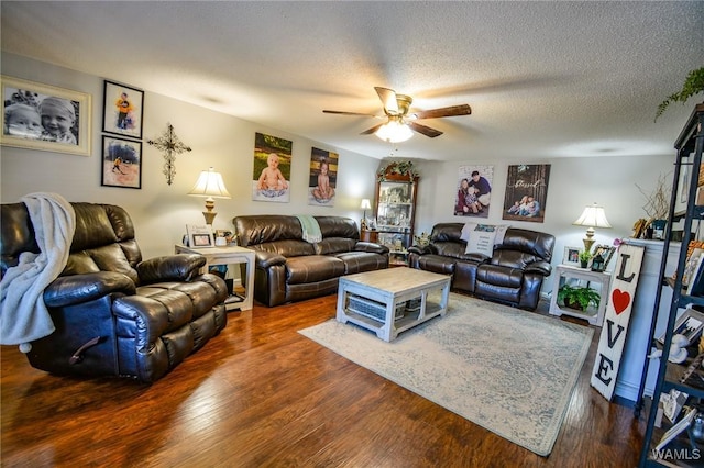 living room with ceiling fan, dark hardwood / wood-style floors, and a textured ceiling