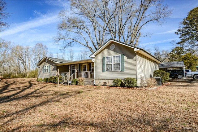 single story home with a porch, a carport, a front yard, and central air condition unit