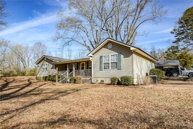 single story home with a porch, a carport, a front yard, and central air condition unit