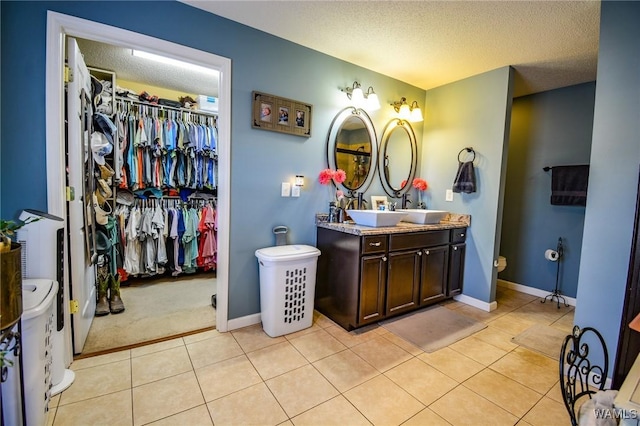 bathroom featuring vanity, tile patterned flooring, and a textured ceiling