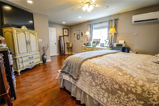 bedroom with ceiling fan, dark hardwood / wood-style floors, a textured ceiling, and an AC wall unit