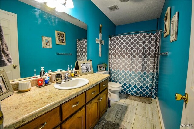 bathroom with vanity, toilet, a textured ceiling, and walk in shower