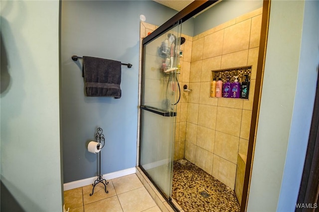 bathroom with a shower with shower door and tile patterned floors