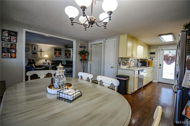 dining area featuring dark hardwood / wood-style flooring, a chandelier, and a textured ceiling