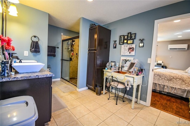 bathroom featuring a wall mounted air conditioner, a shower with shower door, tile patterned flooring, vanity, and a textured ceiling