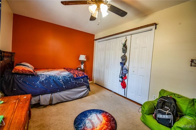 carpeted bedroom featuring ceiling fan, a closet, and a textured ceiling