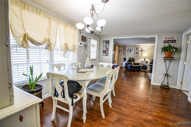 dining room featuring plenty of natural light, dark hardwood / wood-style floors, a notable chandelier, and a textured ceiling