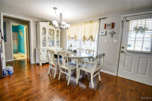 dining room featuring plenty of natural light, dark wood-type flooring, and an inviting chandelier