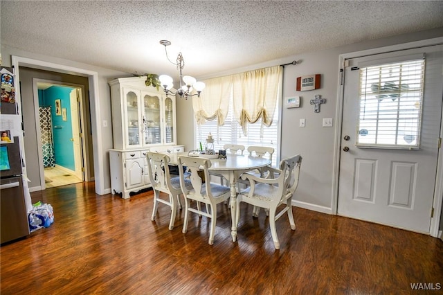 dining area featuring dark hardwood / wood-style flooring, a chandelier, and a textured ceiling