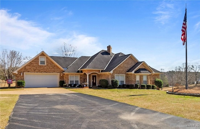 view of front of home featuring brick siding, a front yard, and aphalt driveway