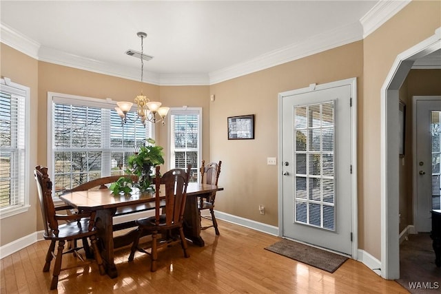 dining area with ornamental molding, light wood-type flooring, and baseboards