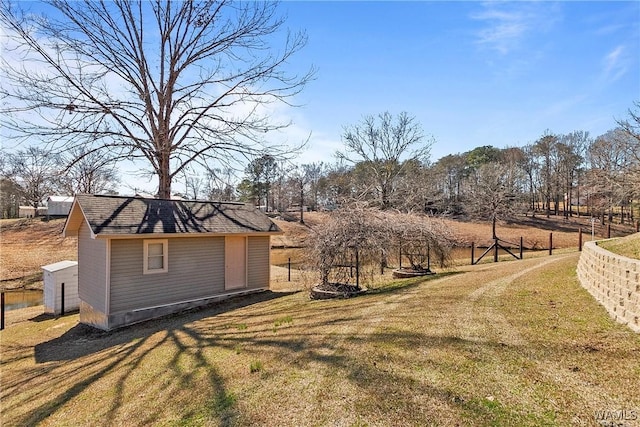 view of yard with fence and an outdoor structure