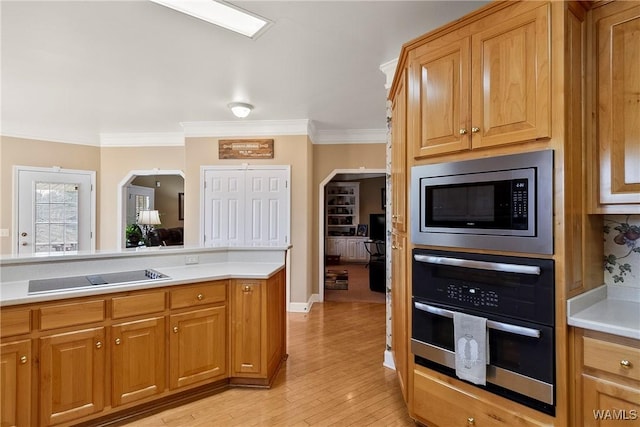 kitchen featuring appliances with stainless steel finishes, arched walkways, crown molding, and light countertops